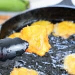 tongs holding a fried plantains