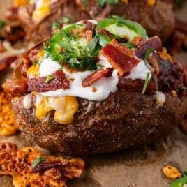 pulled pork baked potato with toppings on a table