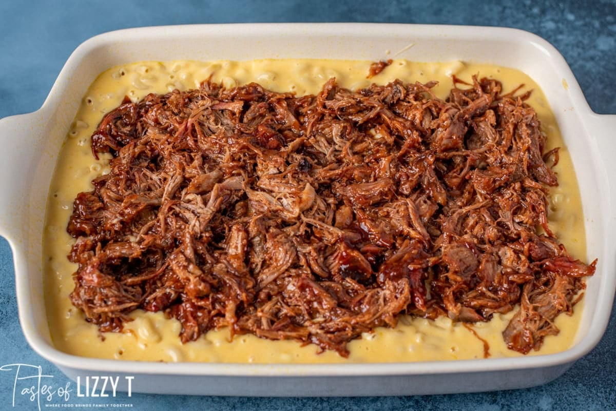 bbq pork over mac and cheese in a casserole dish