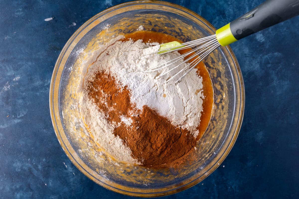 flour and spices over wet ingredients in a bowl