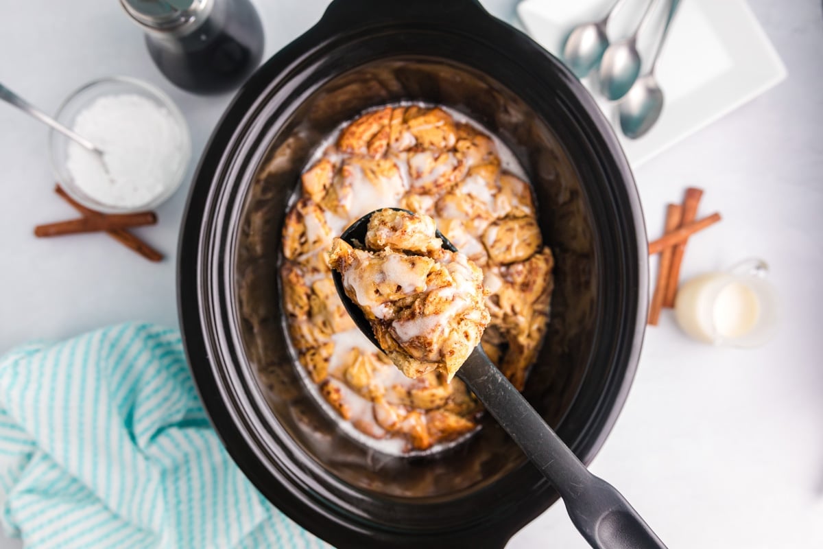 a spoon of cinnamon roll casserole from a slow cooker