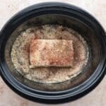 chicken with seasonings and cream cheese in a slow cooker