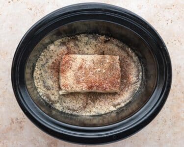 chicken with seasonings and cream cheese in a slow cooker