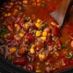 closeup of slow cooker taco soup with a wooden ladle