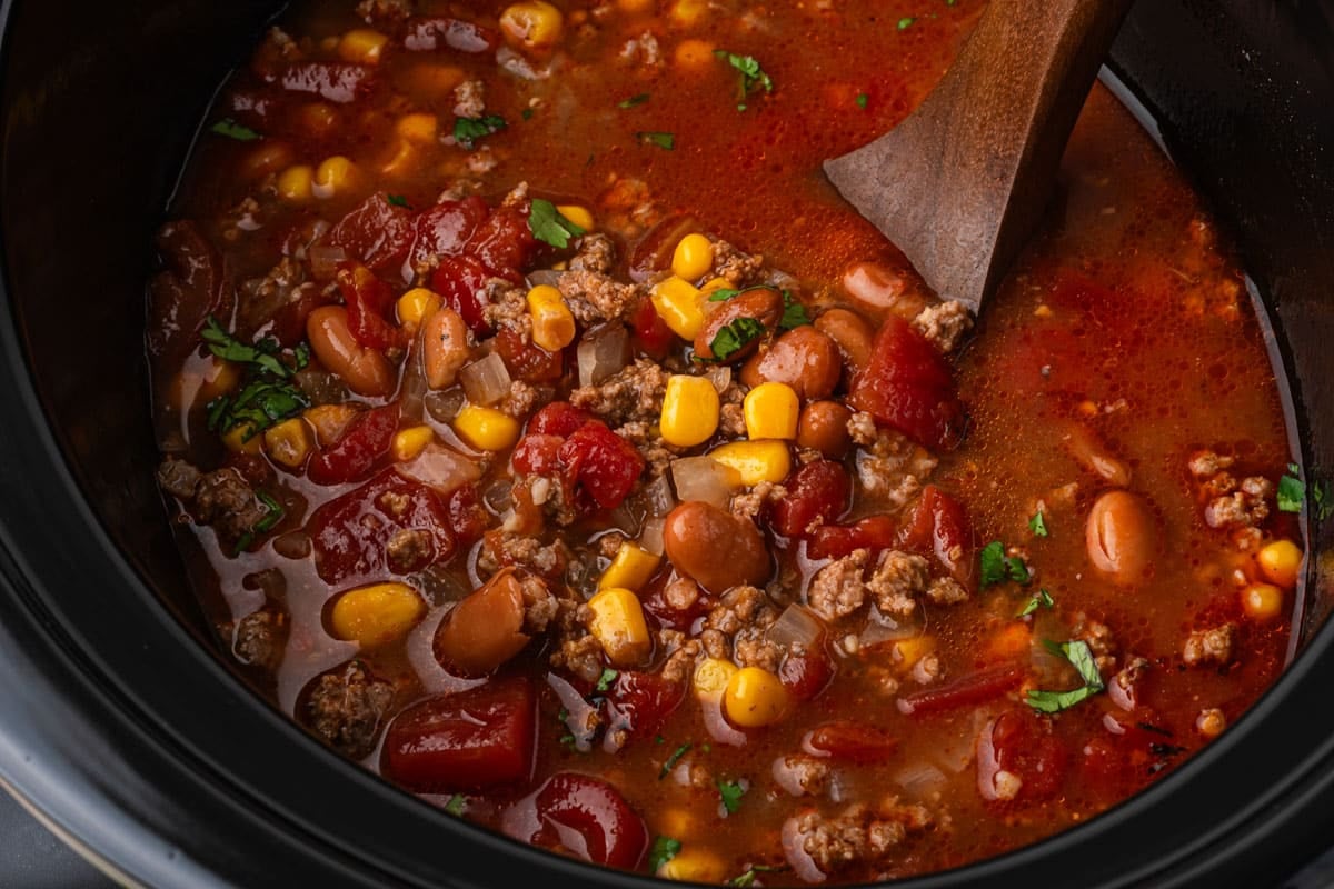 closeup of slow cooker taco soup with a wooden ladle