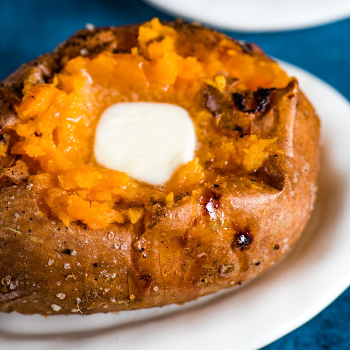 a baked sweet potato on a plate with butter