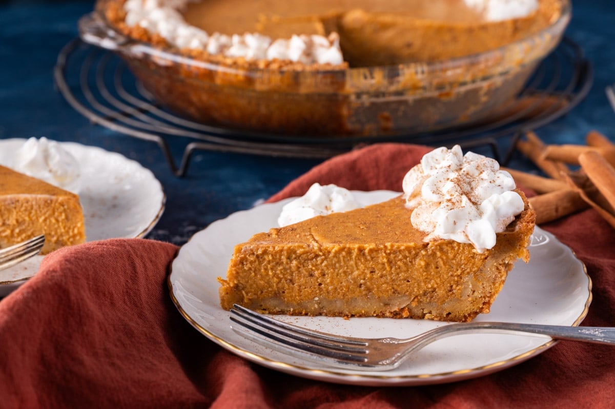 a slice of pumpkin pie with a graham cracker crust on a table