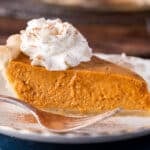 a piece of pumpkin pie with sweetened condensed milk on a plate