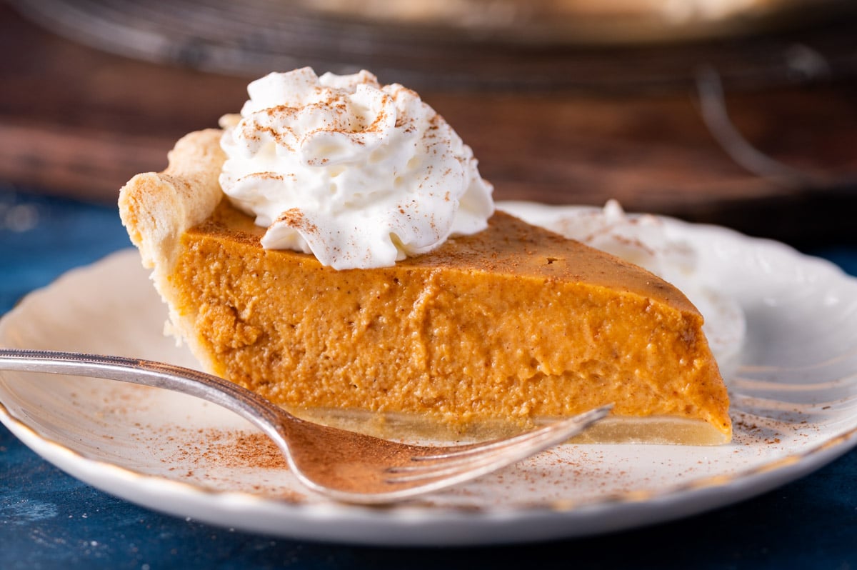 a piece of pumpkin pie with sweetened condensed milk on a plate