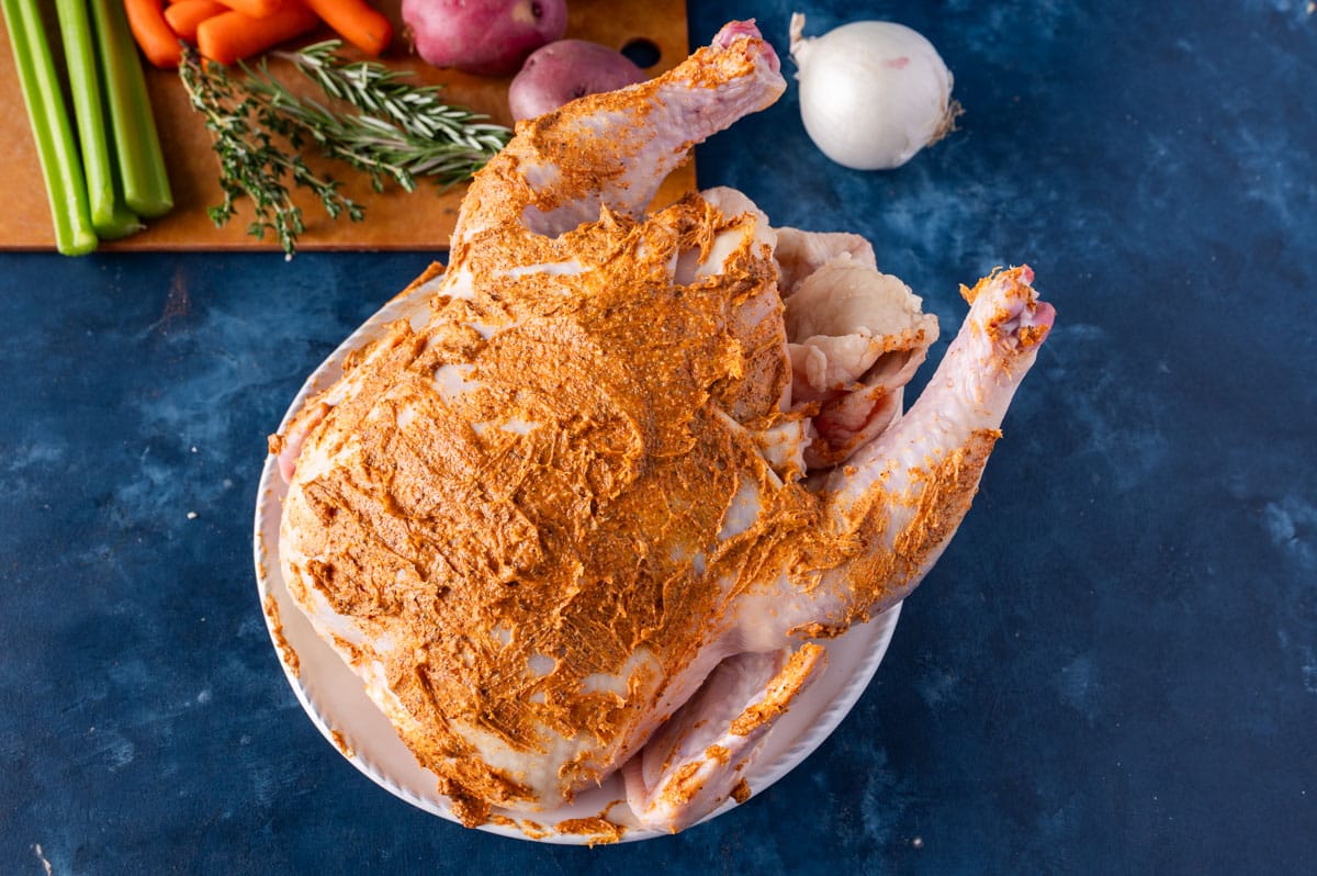 a whole chicken with seasoned butter rubbed on it