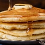 a stack of 4 homemade pancakes with syrup dripping