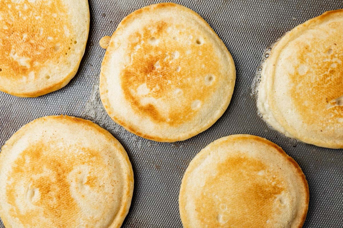 golden brown pancakes cooking on a griddle