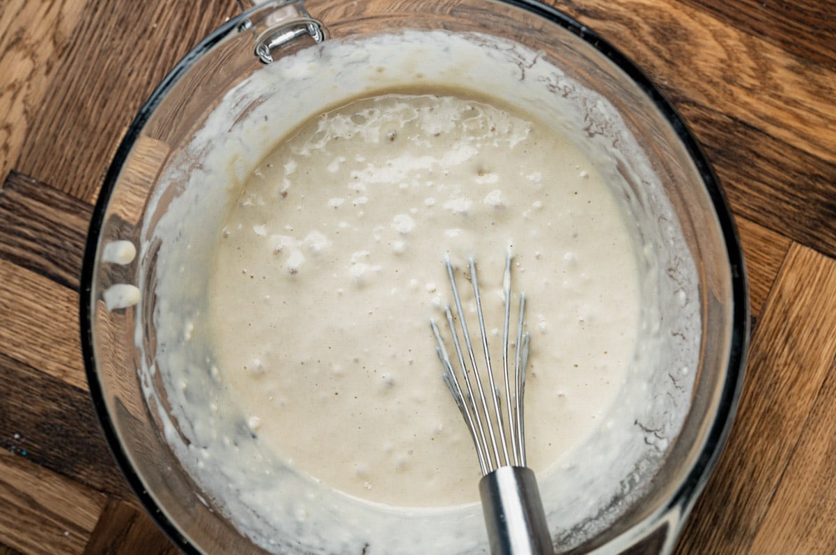 pancake batter in a glass bowl with a whisk