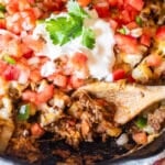 mexican potato skillet in a cast iron pan with a spoon