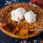 pumpkin crisp in a glass pan with ice cream on top