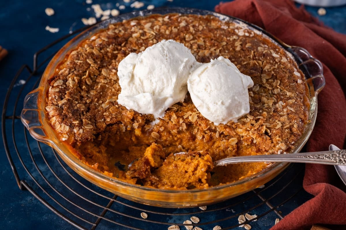pumpkin crisp in a glass pan with ice cream on top