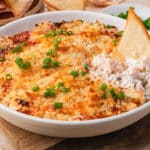 crab rangoon dip in a bowl with a chip