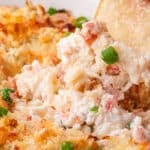 closeup of a chip dipping into hot crab dip