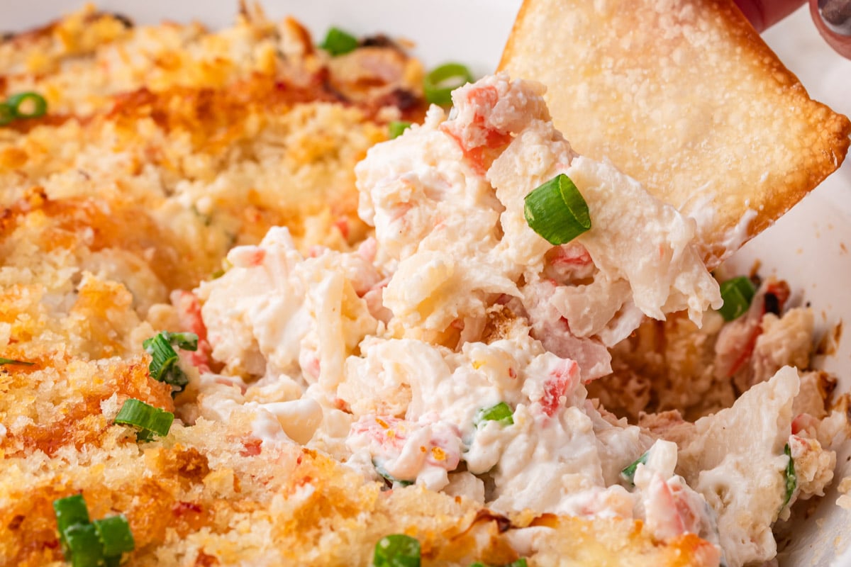 closeup of a chip dipping into hot crab dip
