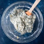 cheesy spinach artichoke mixture in a glass bowl