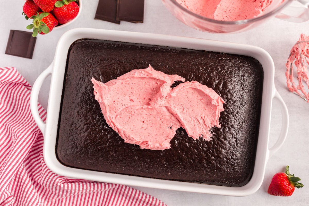 a baked cake with strawberry frosting smeared on top