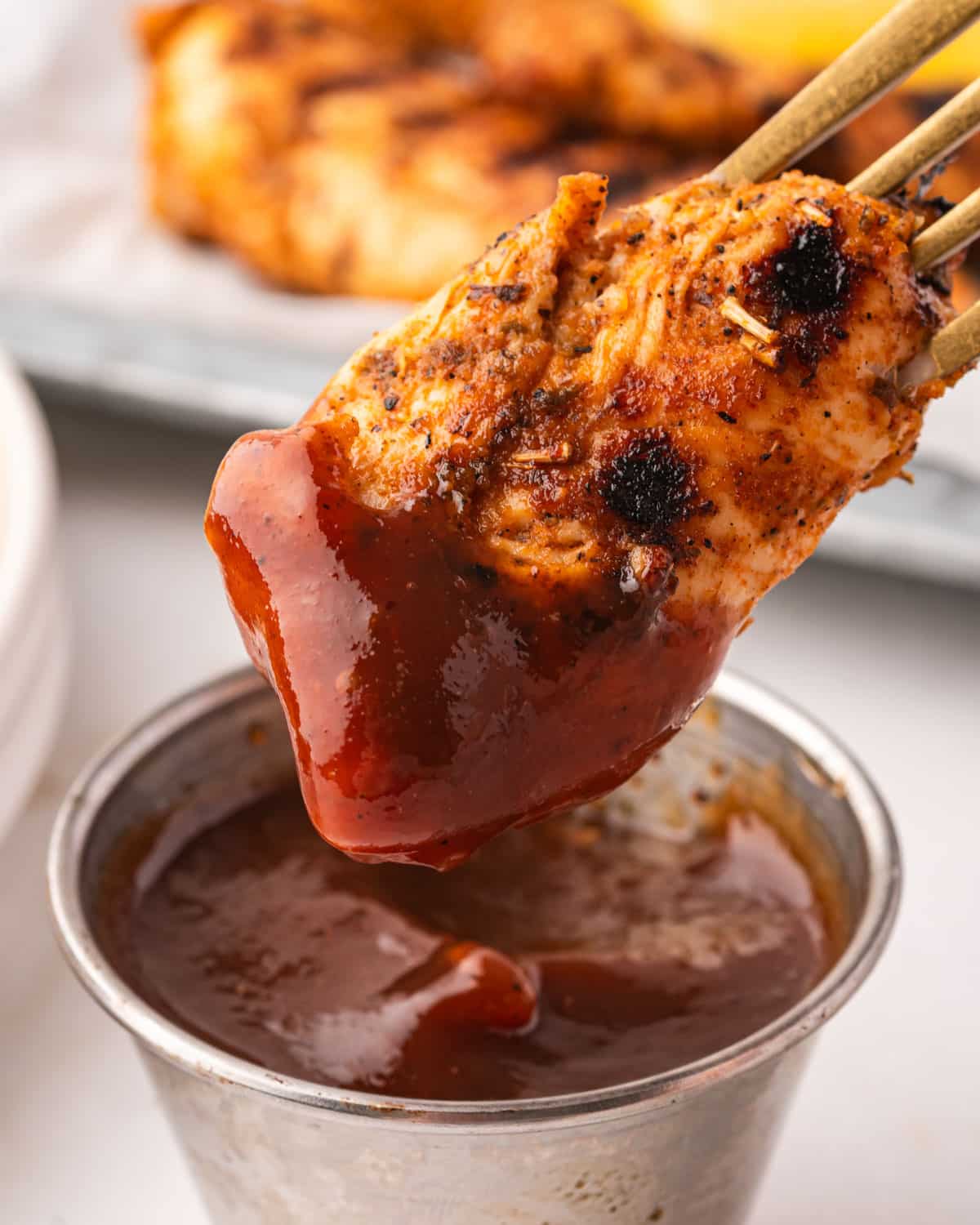 chicken dipping into barbecue sauce