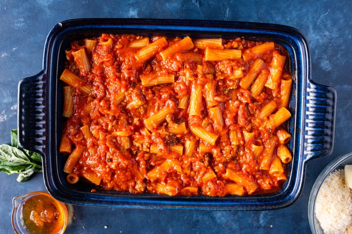 uncooked pasta and sauce in a baking pan