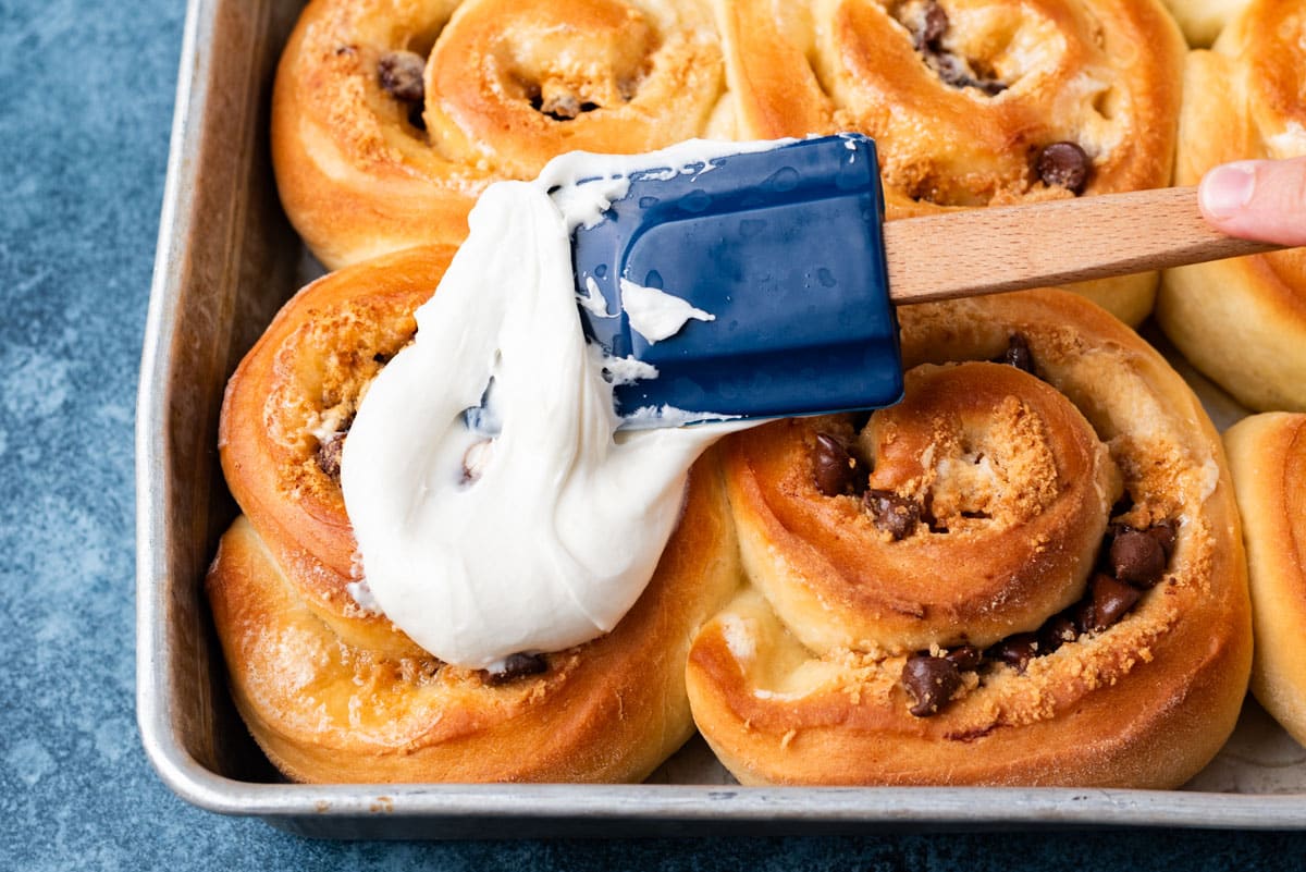 spreading frosting on s'mores cinnamon rolls