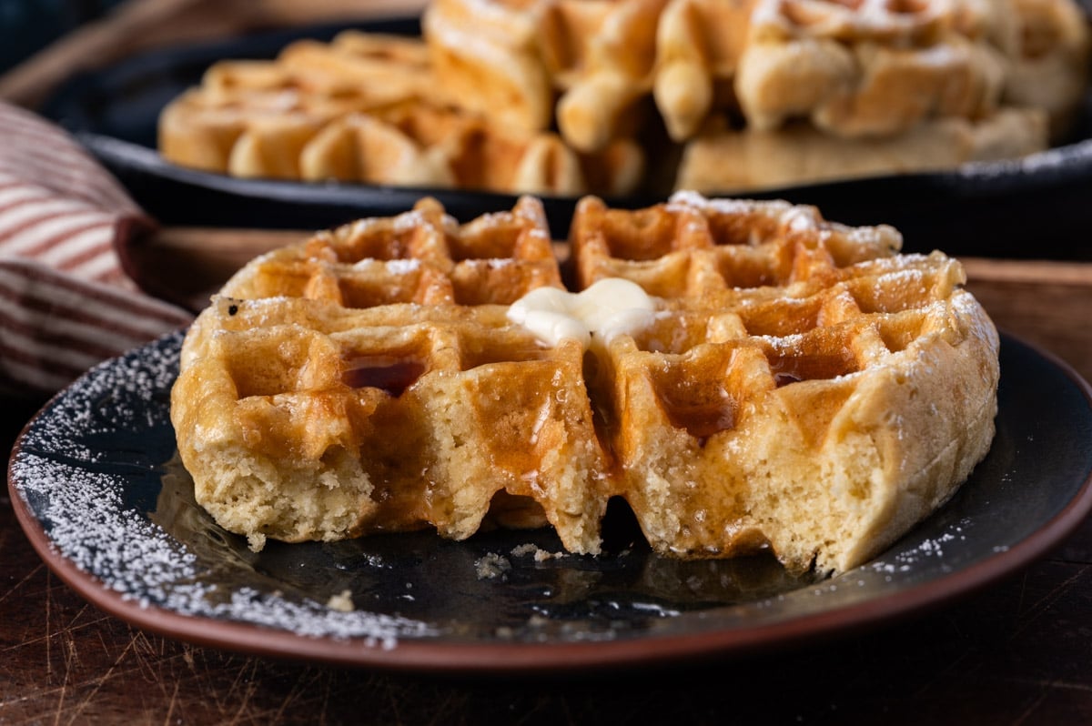 a plate with a waffle on it, with bites taken out