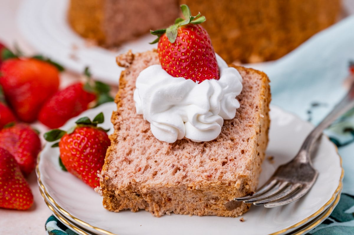 a piece of strawberry angel food cake on a plate with whipped cream