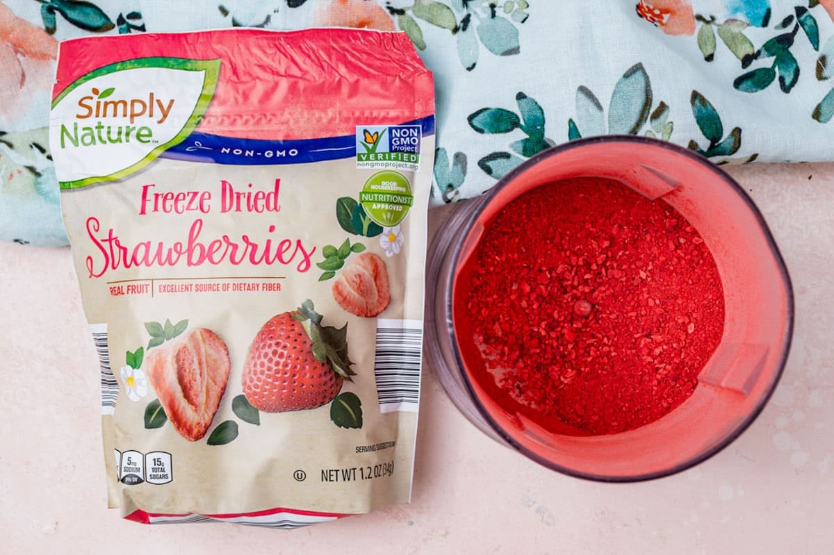 freeze dried strawberries on a table, in a bag and also crushed in a bowl