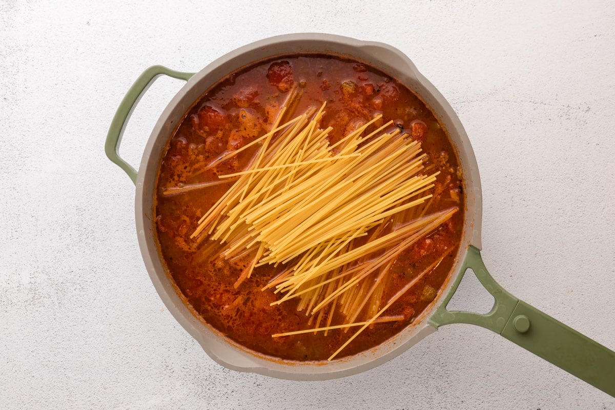 dry pasta over red sauce in a skillet