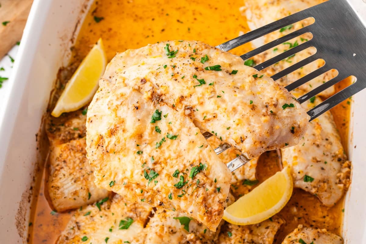 a spatula holding a piece of baked tilapia
