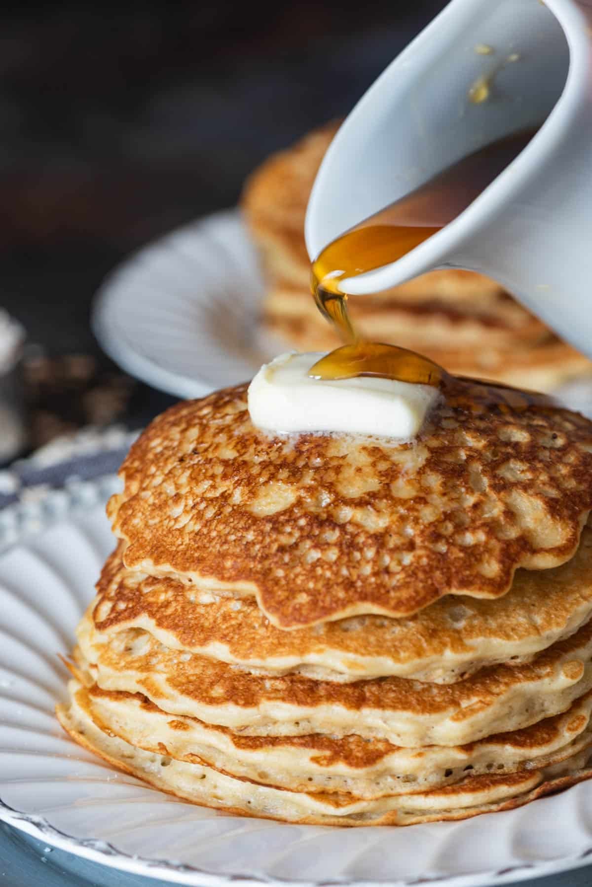 syrup pouring over a stack of pancakes