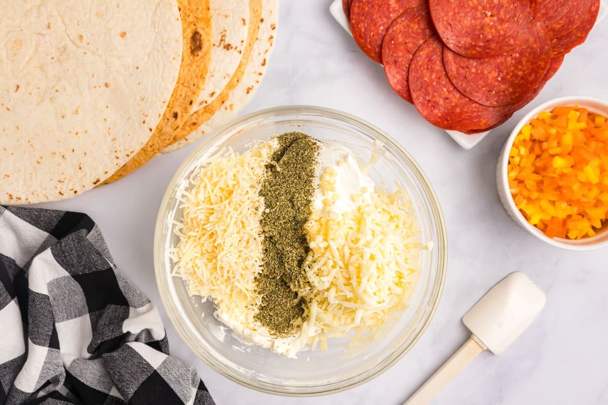 bowl with cheeses for pinwheels on a table