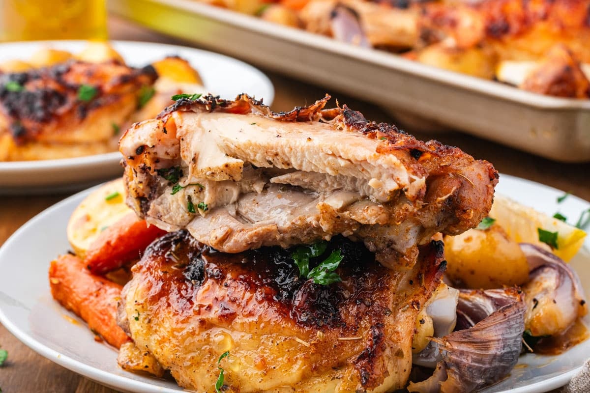 a roasted chicken thigh cut in half on a plate