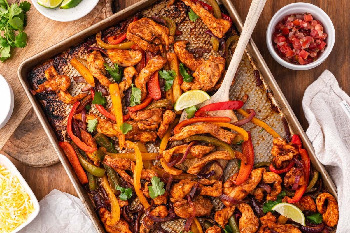 sheet pan chicken fajitas on a table with toppings