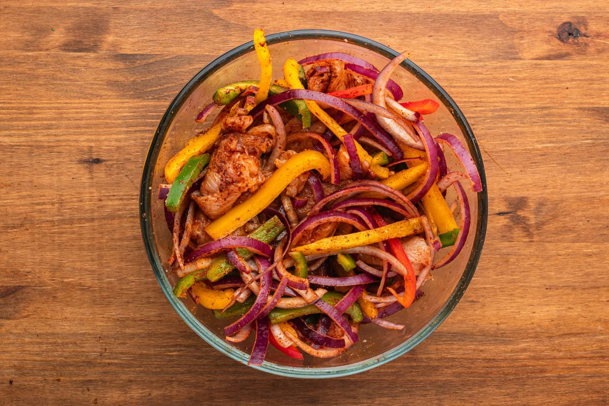 seasoned chicken, peppers and onions in a bowl