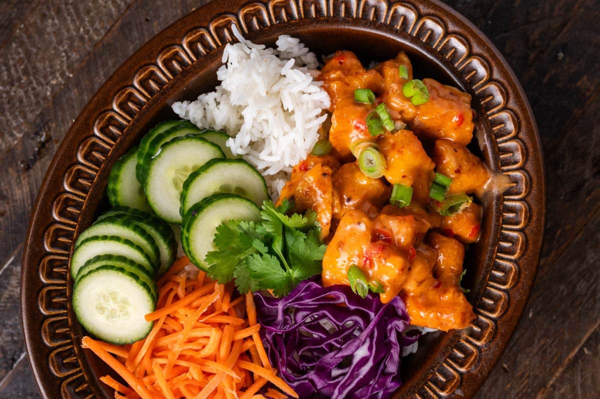 overhead view of a bowl with bang bang chicken and veggies