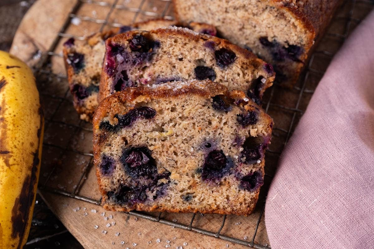 sliced blueberry banana bread on a wire rack