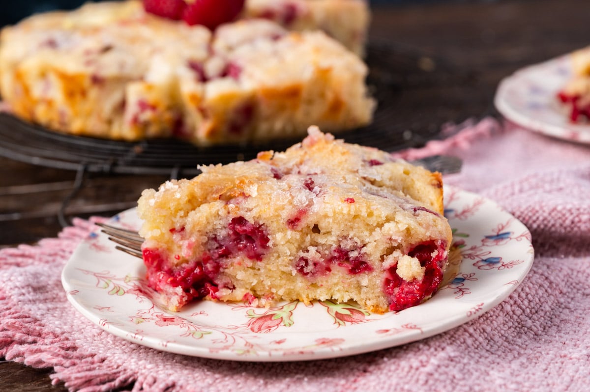 a piece of raspberry lemon cake on a plate with a fork