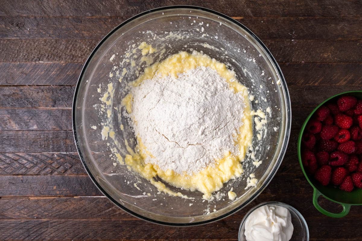 flour over wet ingredients in a bowl for cake