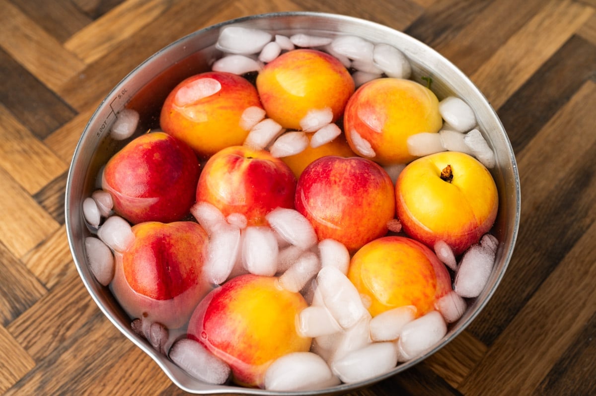 fresh peaches in a bowl of ice water
