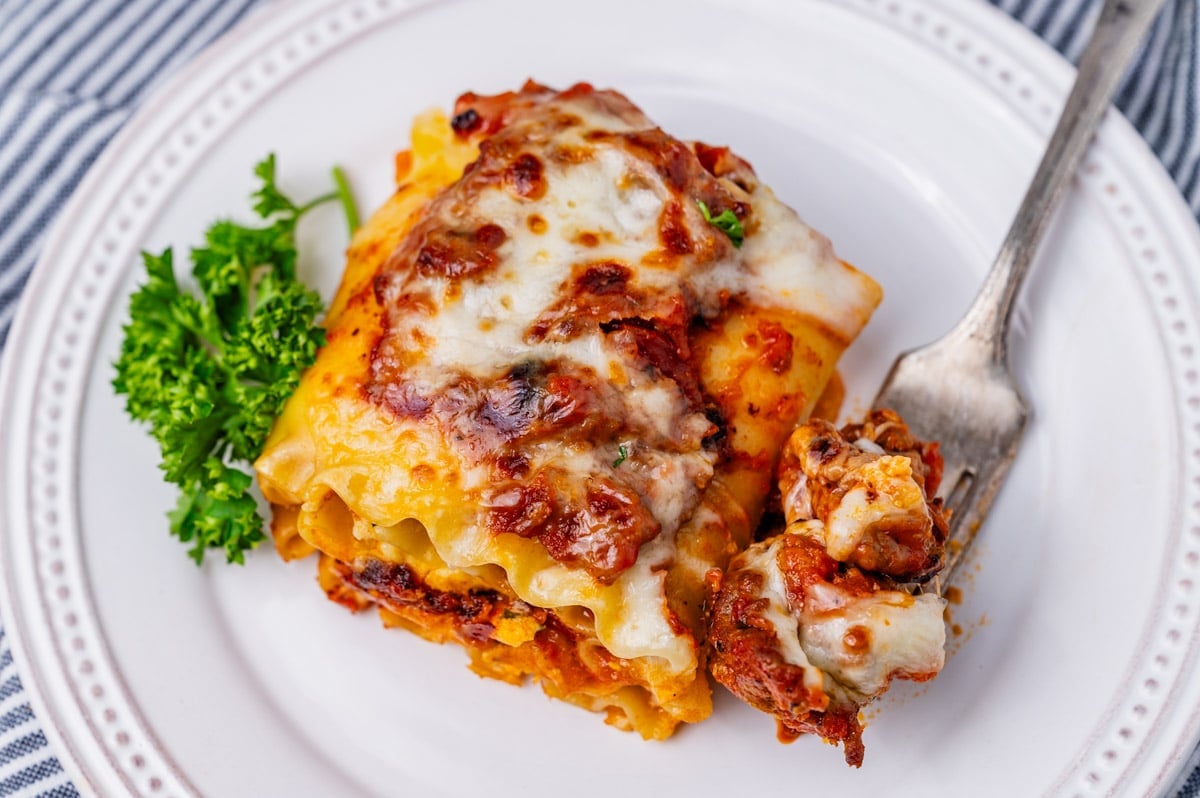 a lasagna roll up on a plate with a fork