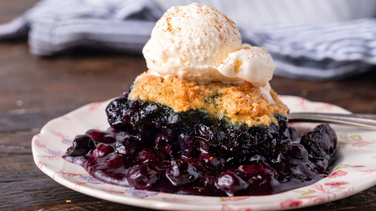 blueberry cobbler on a plate with ice cream