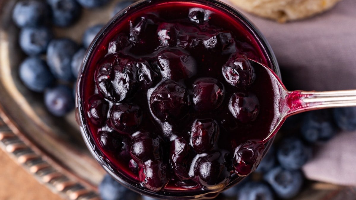 a spoonful of blueberry sauce in a jar