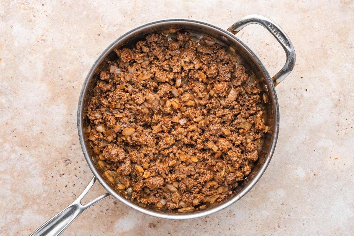 a skillet with seasoned ground beef and onions