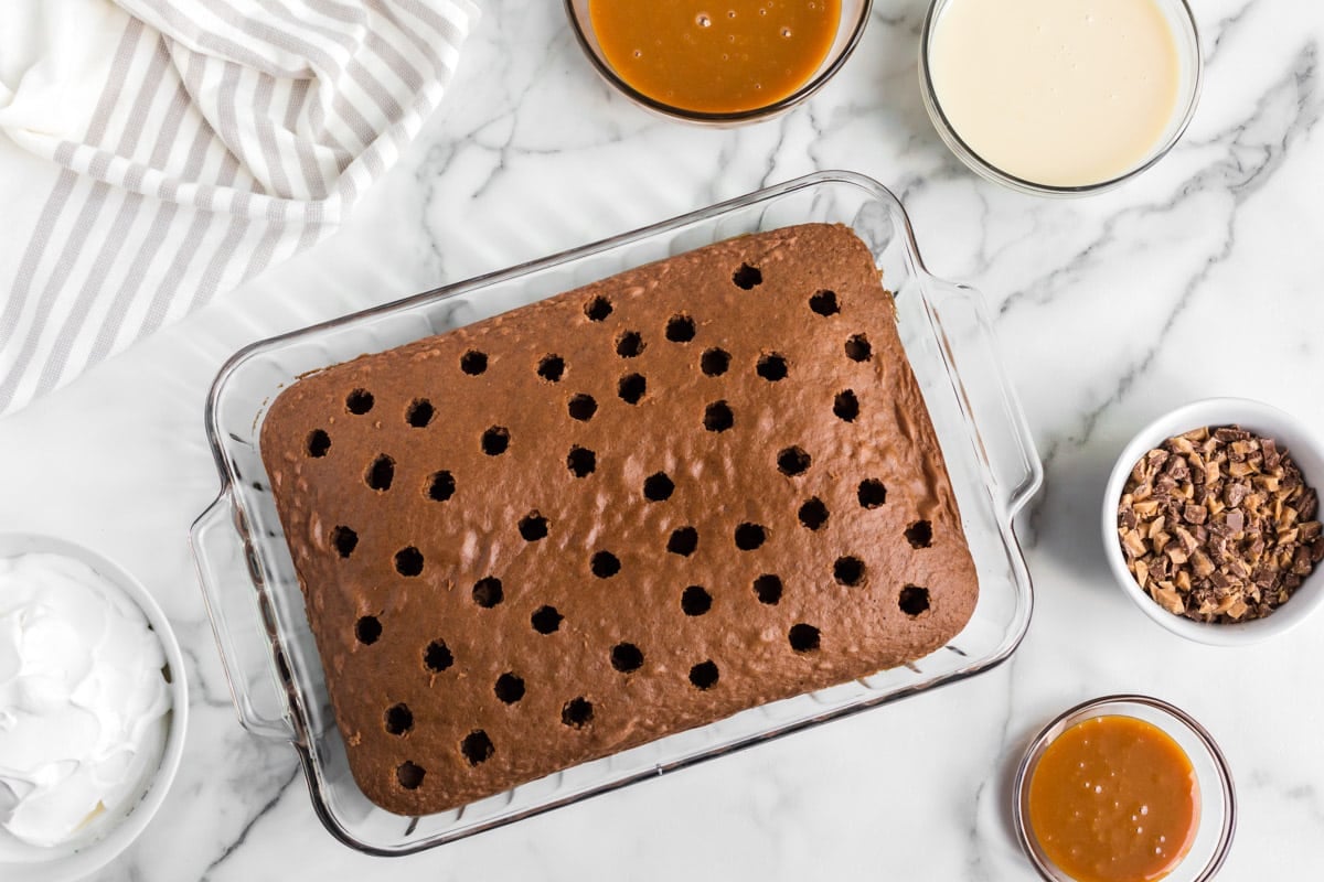 a chocolate cake with holes poked in it on a table