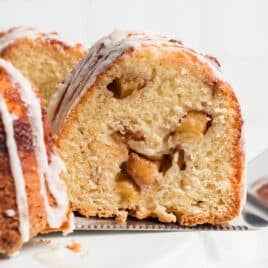 a slice of cinnamon peach bundt cake on a spatula