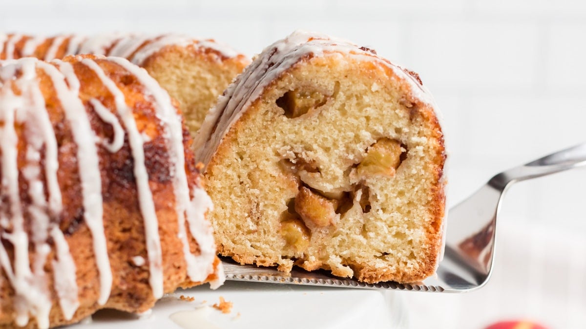 a slice of cinnamon peach bundt cake on a spatula